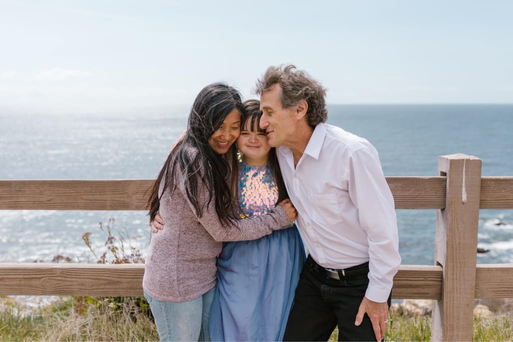 Family posing for picture by the ocean