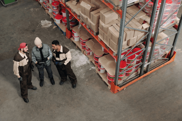 Overhead photo of three men looking at a tablet in a warehouse